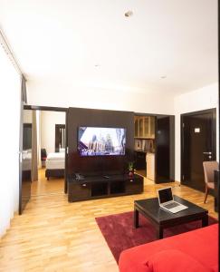a living room filled with furniture and a tv at The Levante Rathaus Apartments in Vienna