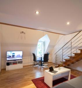 a living room with a staircase and a television at The Levante Rathaus Apartments in Vienna