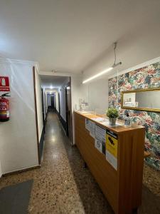 a hallway of an office with a reception desk at Hostal Milmarcos in Zaragoza