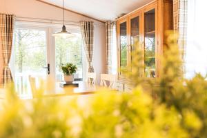a dining room with a table and a large window at Cherry Lodge with Hot Tub in York