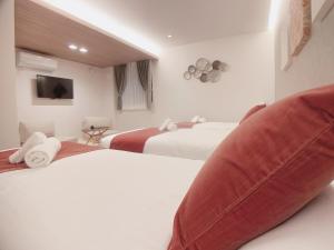HOTEL CLA-SS HIROSHIMA-TOKAICHI في هيروشيما: غرفه فندقيه سريرين مع مخده كبيره