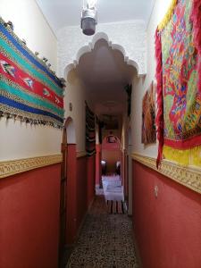 a hallway in a building with red walls and a ceiling at Gîte Tamsoulte in Imlil