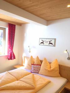 een slaapkamer met een groot bed met gele kussens bij Wöscherhof in Kaltenbach