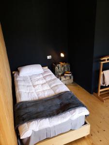 Cama grande en habitación con pared negra en A North Homestay, en Omalo