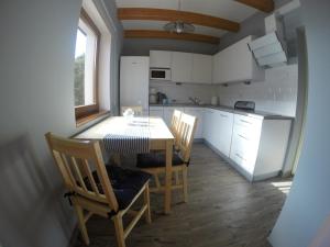 uma cozinha com mesa e cadeiras num quarto em Domek Eve em Giżycko