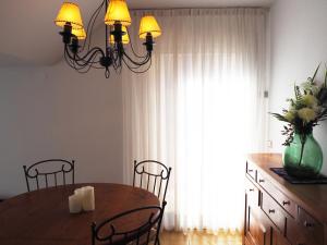 een eettafel met stoelen en een groot raam bij Saromar I Apartament amb gran terrassa, per 6 persones a 5 minuts de la Platja Gran in Platja  d'Aro