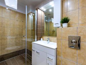 uma casa de banho com um lavatório e um chuveiro em VacationClub – Zachód Słońca Apartament 22 em Mielno