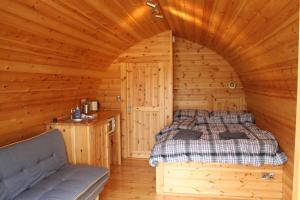 a bedroom with a bed in a wooden cabin at Glamping at Spire View Meadow in Lincoln