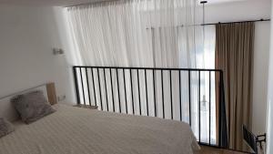 - une chambre avec un lit et une grande fenêtre dans l'établissement Loft in city center-Prime rentals, à Kaunas