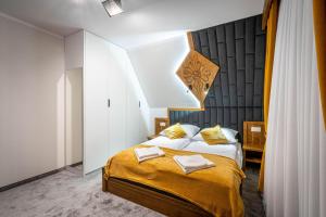 a bedroom with a king sized bed with yellow sheets at Stylovy in Białka Tatrzanska