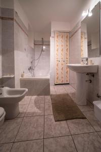 ein Badezimmer mit einem Waschbecken, einer Badewanne und einem WC in der Unterkunft FISHERMAN in Pisogne