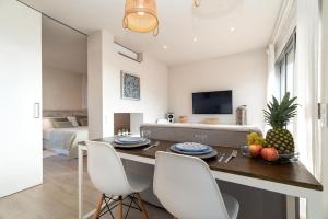 uma sala de estar com uma mesa e cadeiras brancas em Gava Ocean View em Gavà