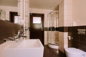 a bathroom with a white sink and a toilet at Szklane Domy in Zakopane