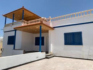 a white house with a balcony on top of it at Gedara Guesthouse: enjoy unforgettable scenes in Um Qeis