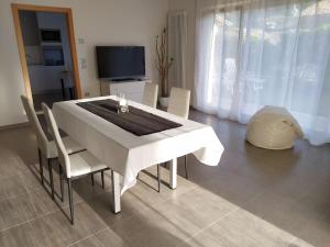 - une table et des chaises blanches dans le salon dans l'établissement Casa Mirella (cipat 022236-AT-849841), à Vigolo Vattaro