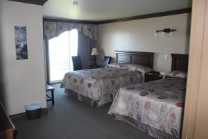 um quarto de hotel com duas camas e uma janela em Manoir sur Mer em Sainte-Anne-des-Monts