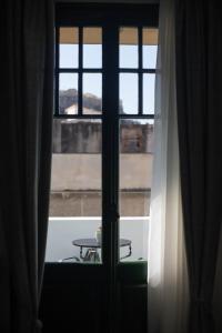 a window that is open in a room at Pandrosos Divine Suites in Athens