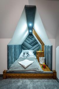 a bed with a blue headboard in a room at Stylovy in Białka Tatrzanska