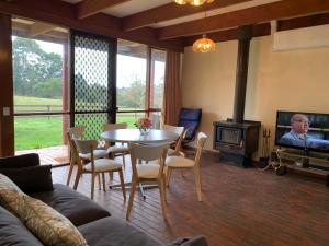uma sala de estar com uma mesa e uma televisão em Willunga Cottage — Sweet Country Retreat em Lyndhurst South