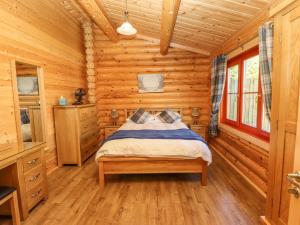 a bedroom with a bed in a log cabin at Holly Lodge in Oakham +34 photos