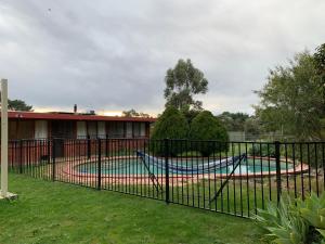 a black fence with a pool in a yard at Willunga Cottage — Sweet Country Retreat in Lyndhurst South