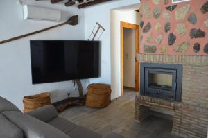 een woonkamer met een open haard en een flatscreen-tv bij Gran Cortijo Viejo Reformado - Cortijo Diego Garcia in Sorbas