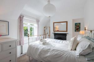 a bedroom with a white bed and a fireplace at Beersbridge Cottage near Titanic Centre & Airport in Belfast +33 photos