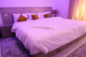 uma grande cama branca com duas toalhas em HOTEL NOON em Laayoune