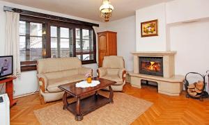 sala de estar con 2 sillas y chimenea en Family Hotel Varosha 2003 en Lovech