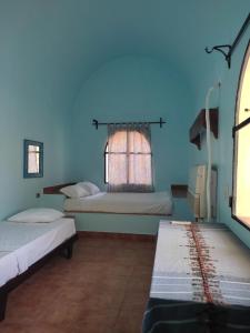 A bed or beds in a room at Nubian Holiday House Aswan