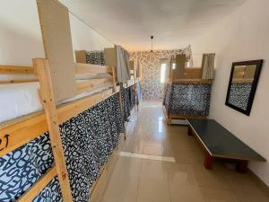 a room with bunk beds and a bench in it at Drago Hostel in Icod de los Vinos