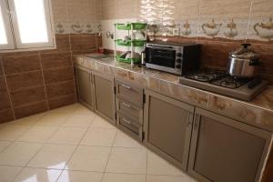 una cocina con estufa y microondas en HOTEL NOON, en Laayoune