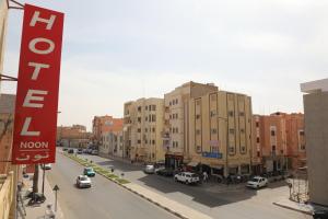 a city street with buildings and cars on the road at HOTEL NOON in Laayoune