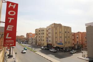 uma rua da cidade com edifícios e carros na estrada em HOTEL NOON em Laayoune