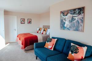 a bedroom with a bed and a blue couch at White Hart Inn in Brightling