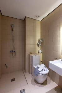 a bathroom with a toilet and a shower and a sink at Saint George Hotel Rooms in Komotini