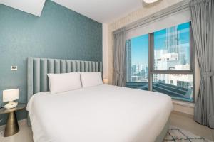 une chambre avec un lit blanc et une grande fenêtre dans l'établissement BellaVista - Sophisticated - 2 BR - 29 Boulevard - Burj Khalifa & Fountain View, à Dubaï 33 autres photos