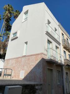 ein weißes Gebäude mit Balkon auf der Seite in der Unterkunft Belém Fantastic Triplex House in Lissabon