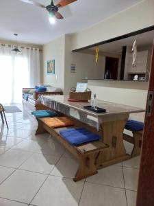 cocina con mesa y bancos en una habitación en Apartamento na Prainha, en Arraial do Cabo