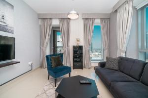 a living room with a couch and a blue chair at BellaVista - Sophisticated - 2 BR - 29 Boulevard - Burj Khalifa & Fountain View in Dubai