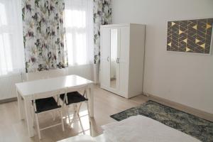 ein weißes Esszimmer mit einem Tisch und einem Fenster in der Unterkunft Vienna4you App 33 you are welcome in Wien