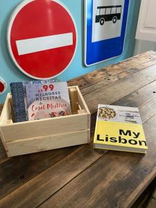 una mesa de madera con una caja de libros y un cartel en Belém Fantastic Triplex House en Lisboa
