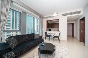 uma sala de estar com um sofá preto e uma mesa em BellaVista - Sophisticated - 2 BR - 29 Boulevard - Burj Khalifa & Fountain View em Dubai