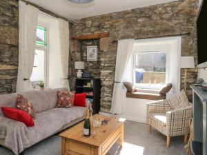 a living room with a stone wall at The Coorie Cove in Helensburgh