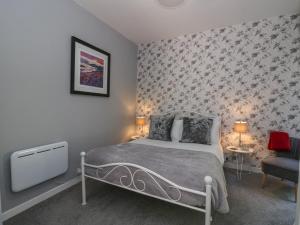 a bedroom with a bed and a chair in it at The Coorie Cove in Helensburgh