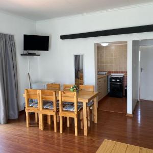 a dining room with a table and chairs and a kitchen at Little Acres Drakensberg Accommodation in Champagne Valley +38 photos