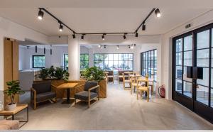 a large room with tables and chairs and windows at Saint George Hotel Rooms in Komotini