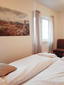 1 dormitorio con cama blanca y ventana en Pilegrimsgården Hotell og Gjestegård en Trondheim