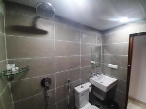 a bathroom with a toilet and a sink and a shower at Hotel Prime Jubilee in Hyderabad +17 photos