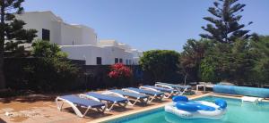 a pool with lounge chairs and a water slide at Villa Celeste in Playa Blanca